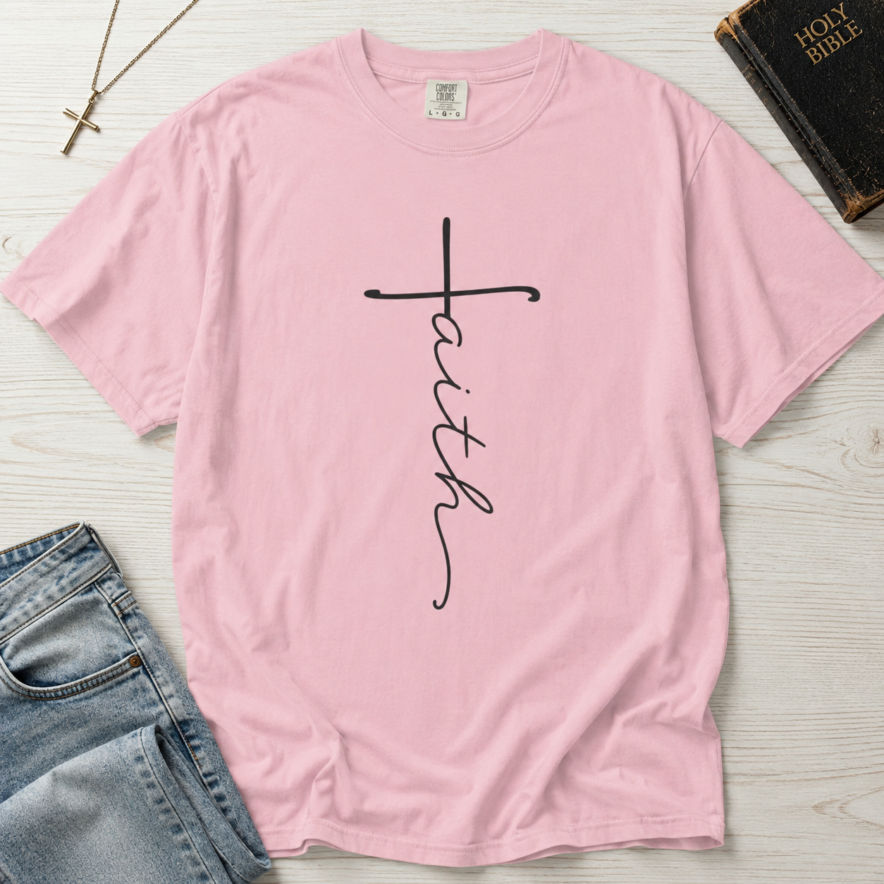 Faith vertical script Christian t-shirt in pastel Blossom pink, minimalist hand-lettered cross design on garment-dyed faith tee.