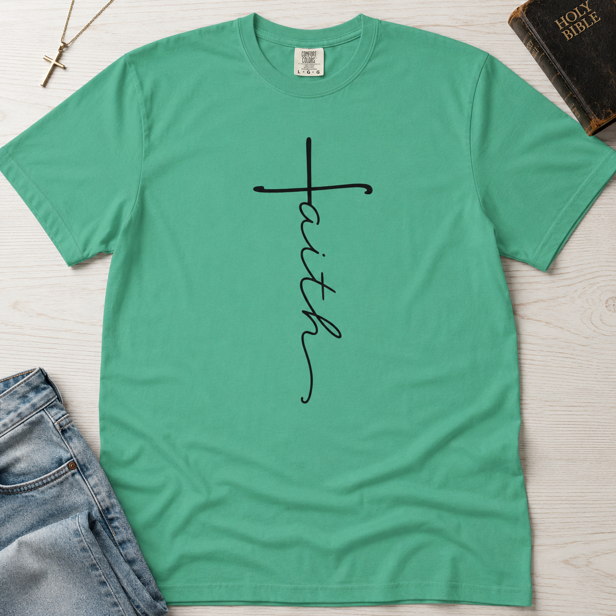 Faith vertical script Christian t-shirt in mint Island Reef green, minimal hand-lettered cross design on garment-dyed cotton.