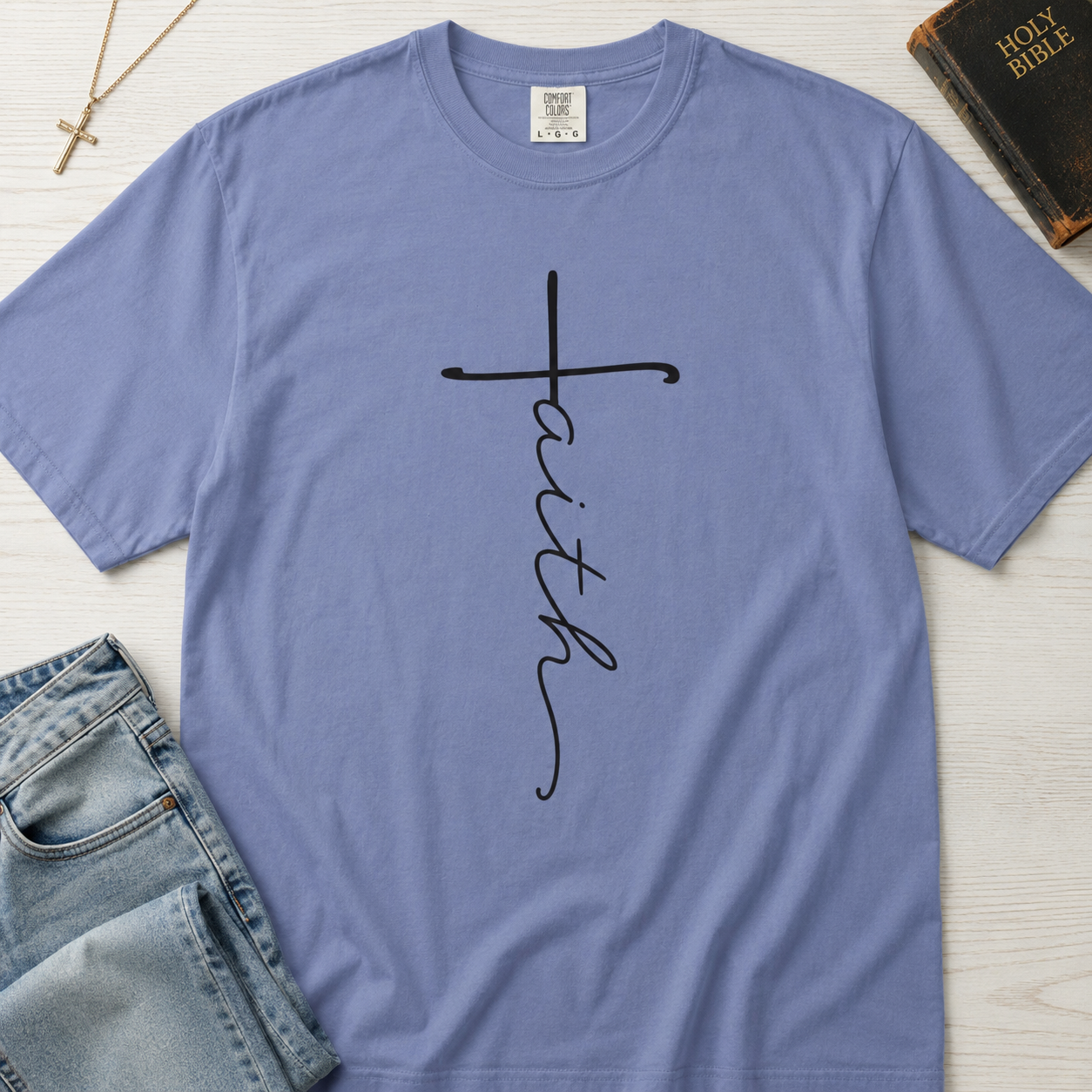 Faith vertical script Christian t-shirt in dusty Blue Jean, minimalist hand-lettered cross design on garment-dyed cotton.