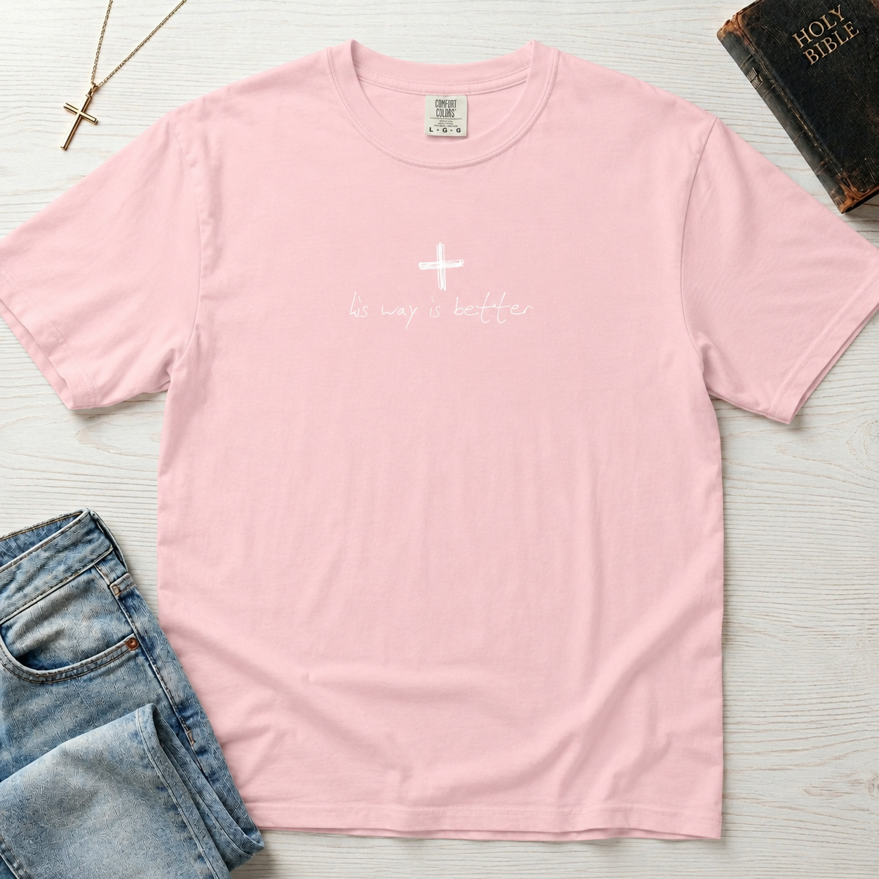 Cross & Chill minimal Christian t-shirt in pastel Blossom pink, garment-dyed tee with small white cross and 'his way is better' script.