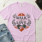 Walk in Love Christian t-shirt in soft lavender (Orchid), garment-dyed tee with sunburst cross, laurel wreath and winding-path heart graphic, styled with Bible and denim.