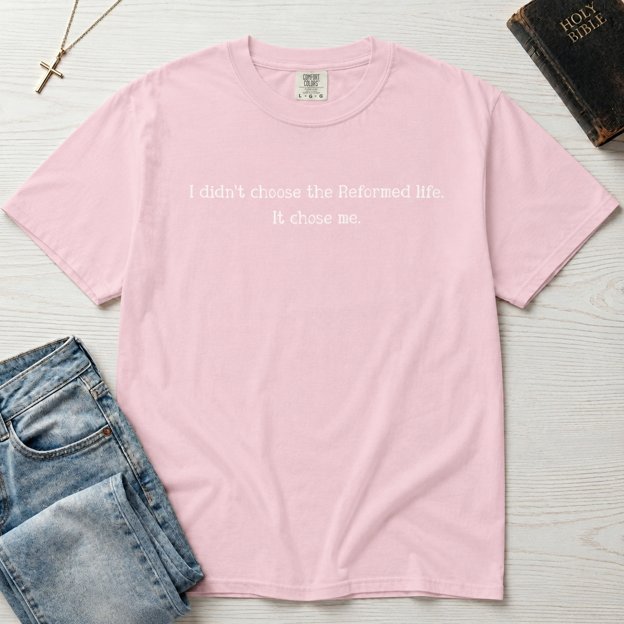 Reformed Life Christian t-shirt in light pink, garment-dyed cotton tee with minimal centered script 'I didn't choose the Reformed life. It chose me.'
