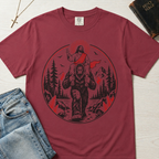 Bigfoot & Jesus Christian t-shirt in dusty rose; circular forest emblem of Jesus riding on Bigfoot's shoulders among pines with a sunburst halo.