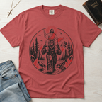 Bigfoot & Jesus Christian t-shirt in mauve rose; circular forest emblem of Jesus riding on Bigfoot's shoulders among pines with a sunburst halo.