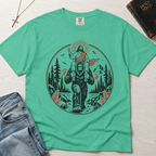 Bigfoot & Jesus Christian t-shirt in mint green; circular forest emblem of Jesus riding on Bigfoot's shoulders among pines with a sunburst halo.