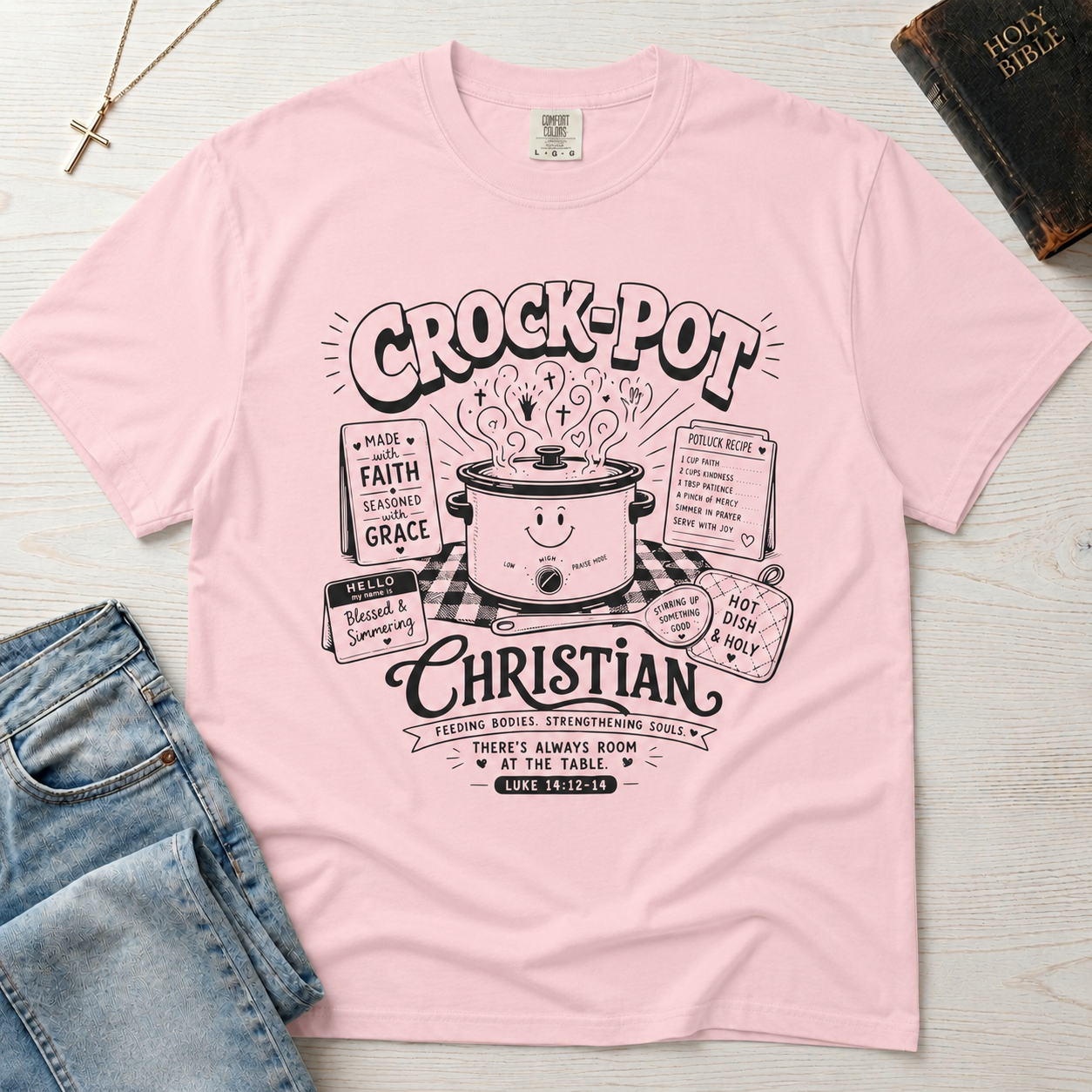 Crock-Pot Christian t-shirt in light pink, garment-dyed tee; retro graphic of a smiling slow cooker with 'faith' and 'grace' banners.