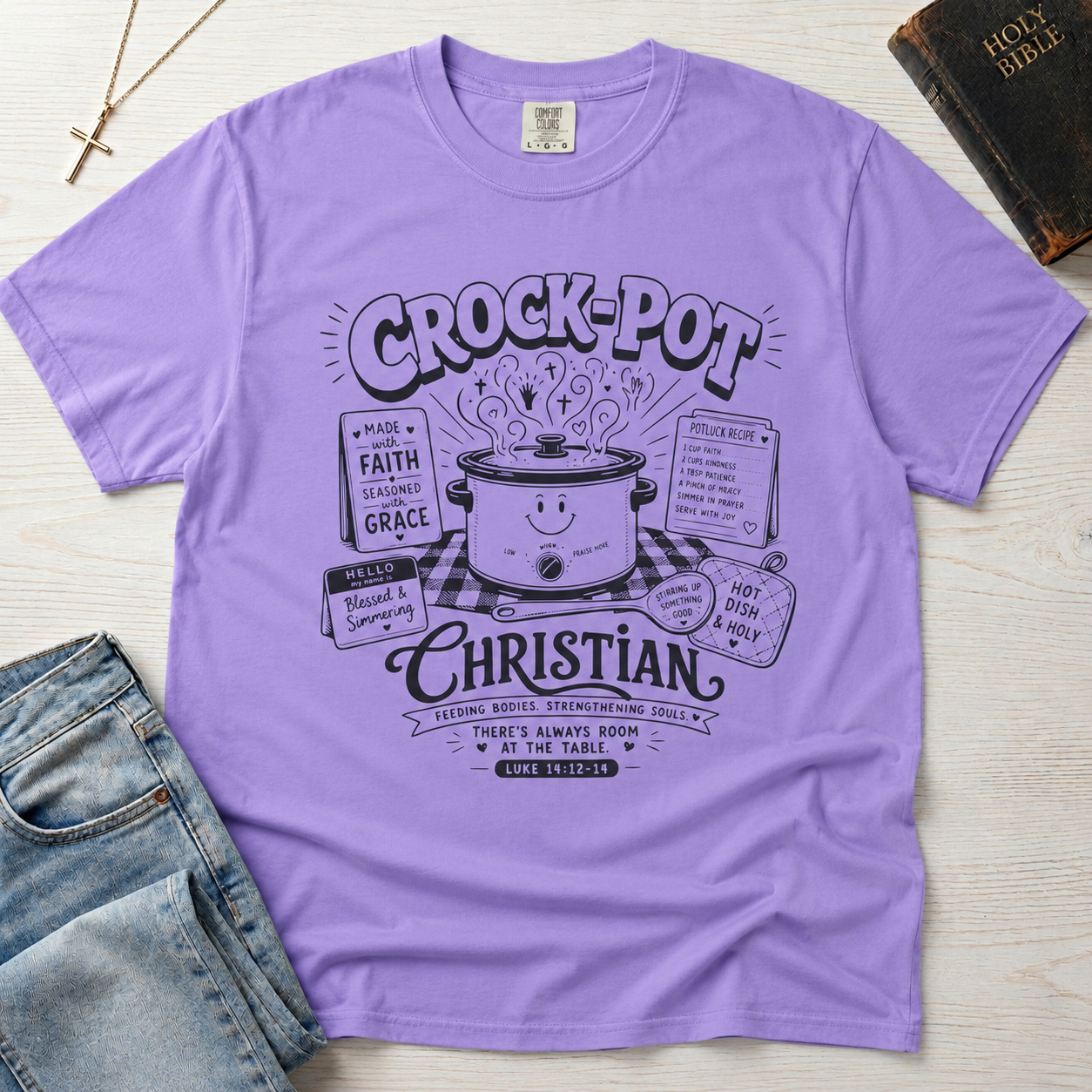 Crock-Pot Christian t-shirt in lavender, garment-dyed tee; retro graphic of a smiling slow cooker with 'faith' and 'grace' banners.