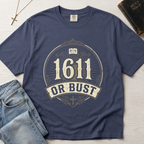1611 Or Bust Christian t-shirt in steel blue; vintage badge with large '1611' over an 'Or Bust' banner, ornate frame with open Bible and cross.