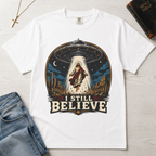I Still Believe Christian t-shirt in white; retro graphic of a UFO beaming up a figure over desert cactus at night with 'I Still Believe' banner.