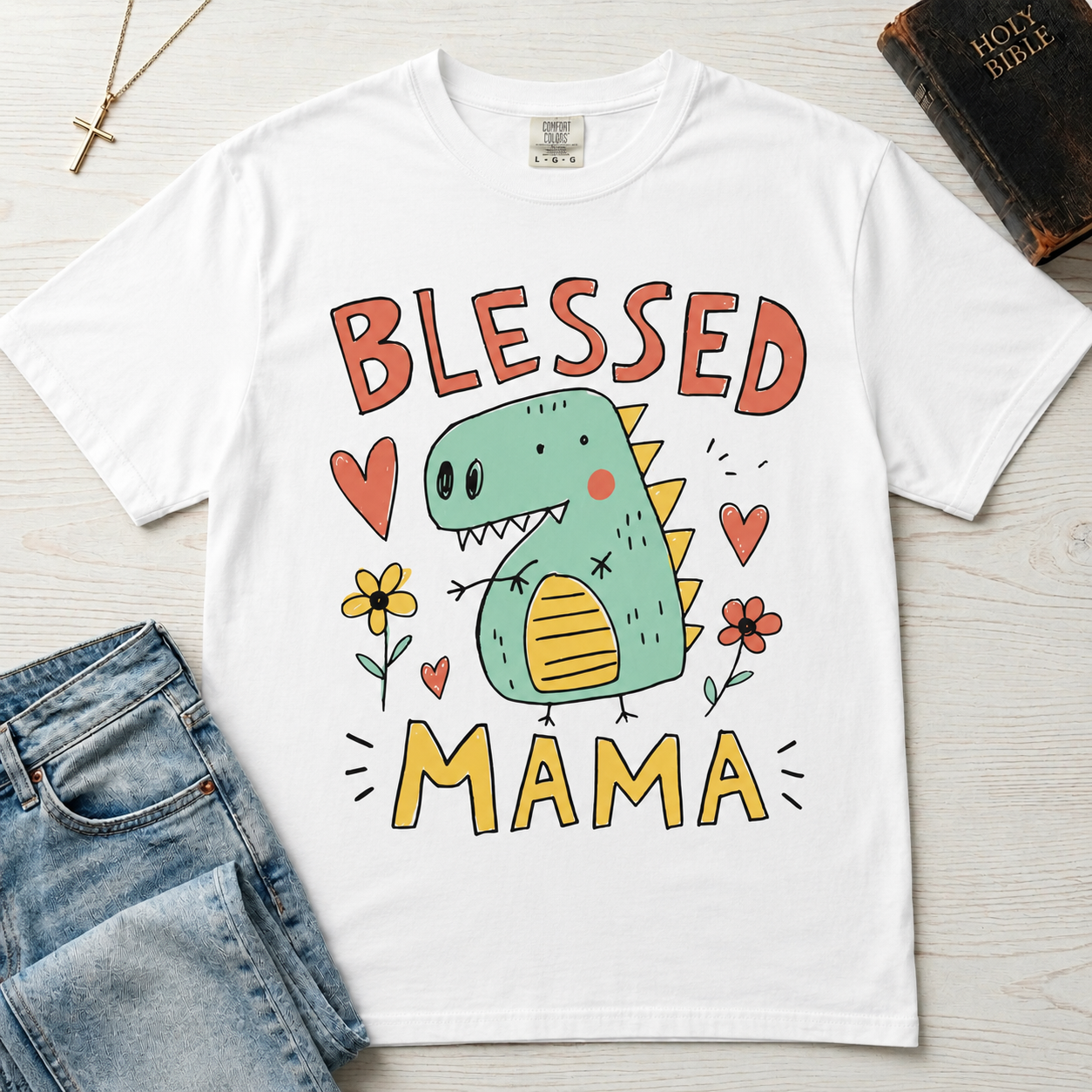 Blessed Mama Dinosaur t-shirt in white; cute cartoon green dino among flowers and hearts with 'Blessed Mama' lettering, faith mom tee.