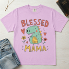Blessed Mama Dinosaur t-shirt in lavender; cute cartoon green dino among flowers and hearts with 'Blessed Mama' lettering, faith mom tee.
