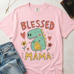 Blessed Mama Dinosaur t-shirt in light pink; cute cartoon green dino among flowers and hearts with 'Blessed Mama' lettering, faith mom tee.