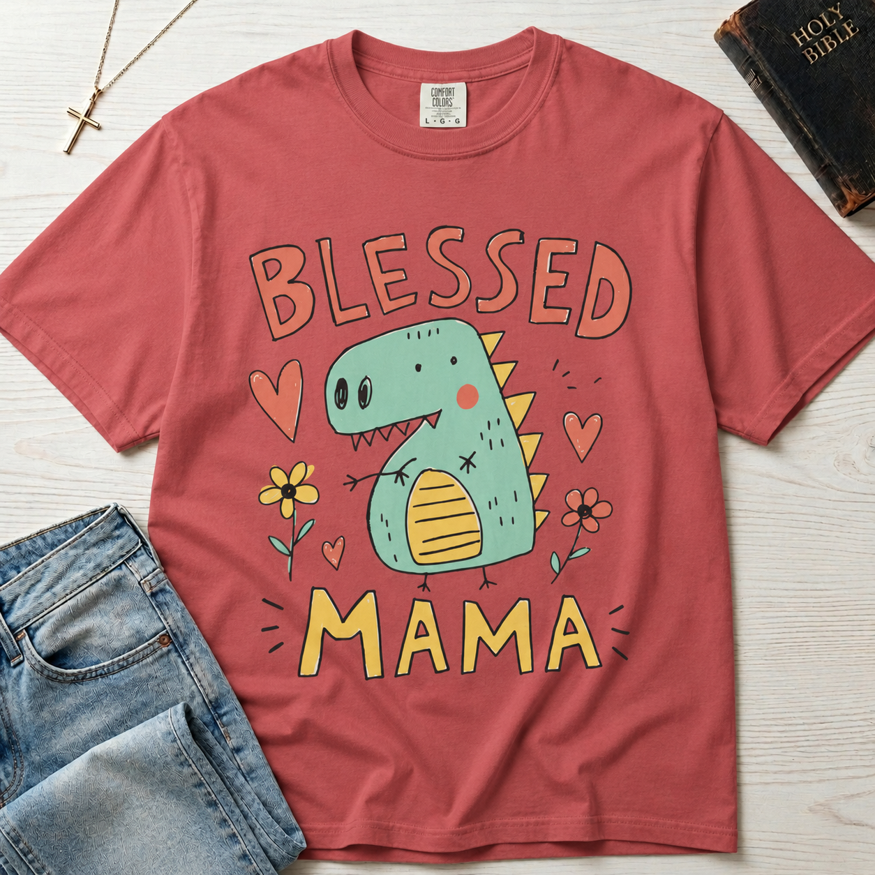 Blessed Mama Dinosaur t-shirt in dusty rose; cute cartoon green dino among flowers and hearts with 'Blessed Mama' lettering, faith mom tee.