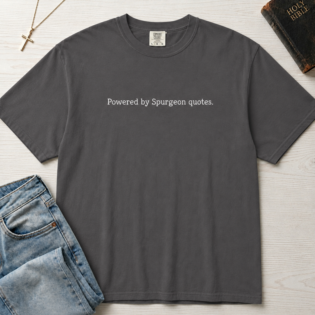 Powered by Spurgeon Quotes Christian t-shirt in gray, garment-dyed tee with minimal small centered text 'Powered by Spurgeon quotes'.