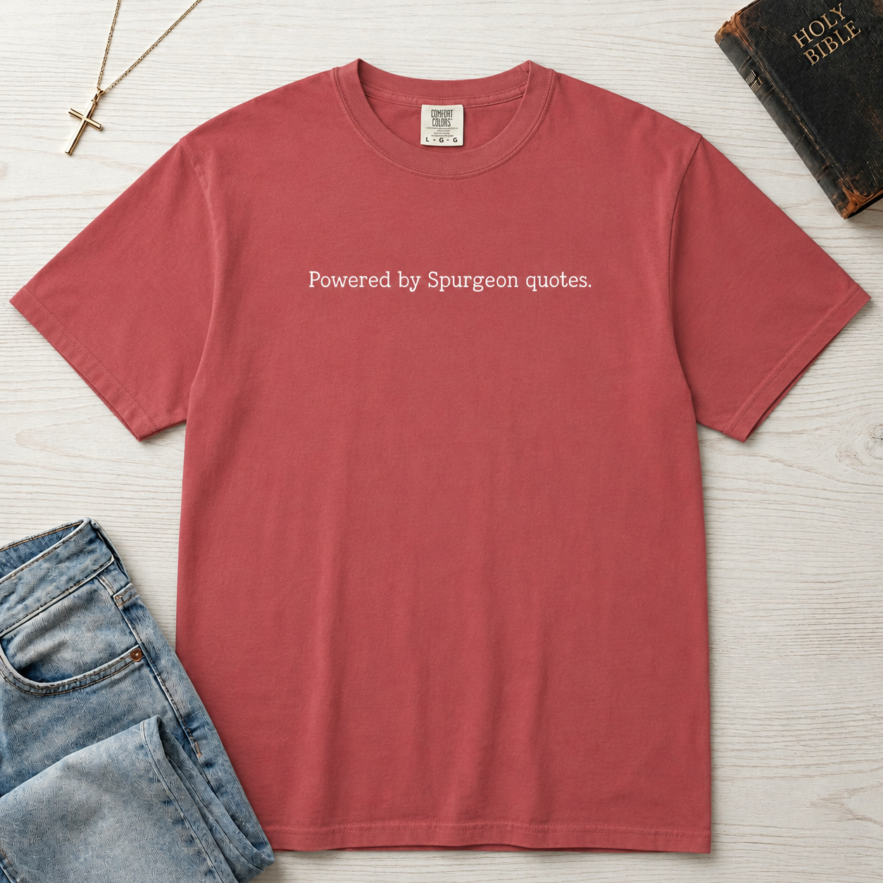 Powered by Spurgeon Quotes Christian t-shirt in mauve rose, garment-dyed tee with minimal small centered text 'Powered by Spurgeon quotes'.