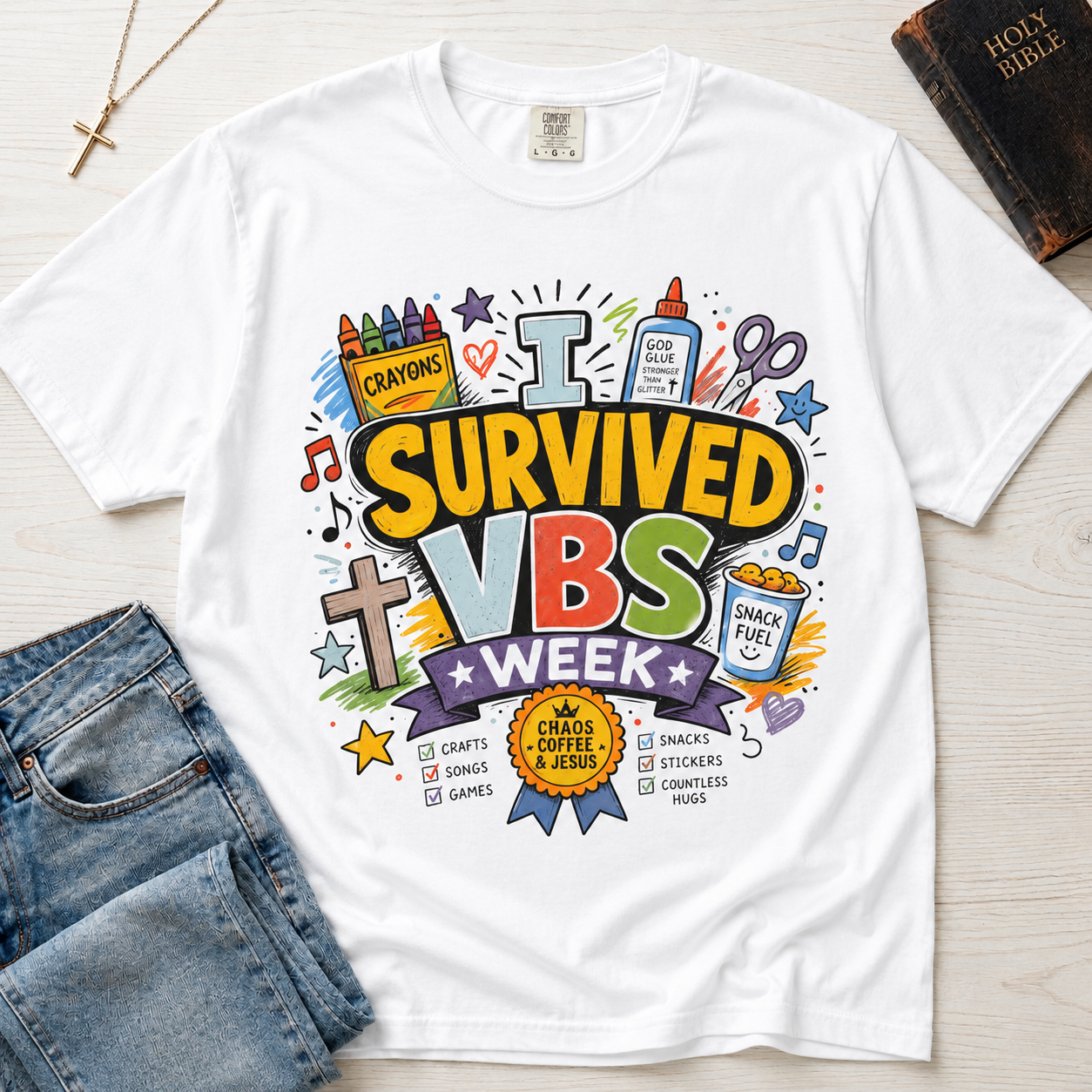 I Survived VBS Week Christian t-shirt in white; playful graphic with crayons, cross, juice box, stars and an award ribbon, VBS souvenir tee.