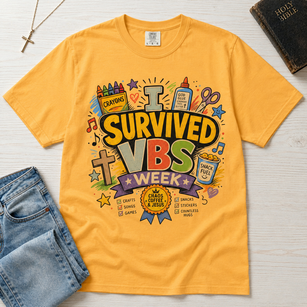 I Survived VBS Week Christian t-shirt in marigold yellow; playful graphic with crayons, cross, juice box, stars and an award ribbon, VBS souvenir tee.