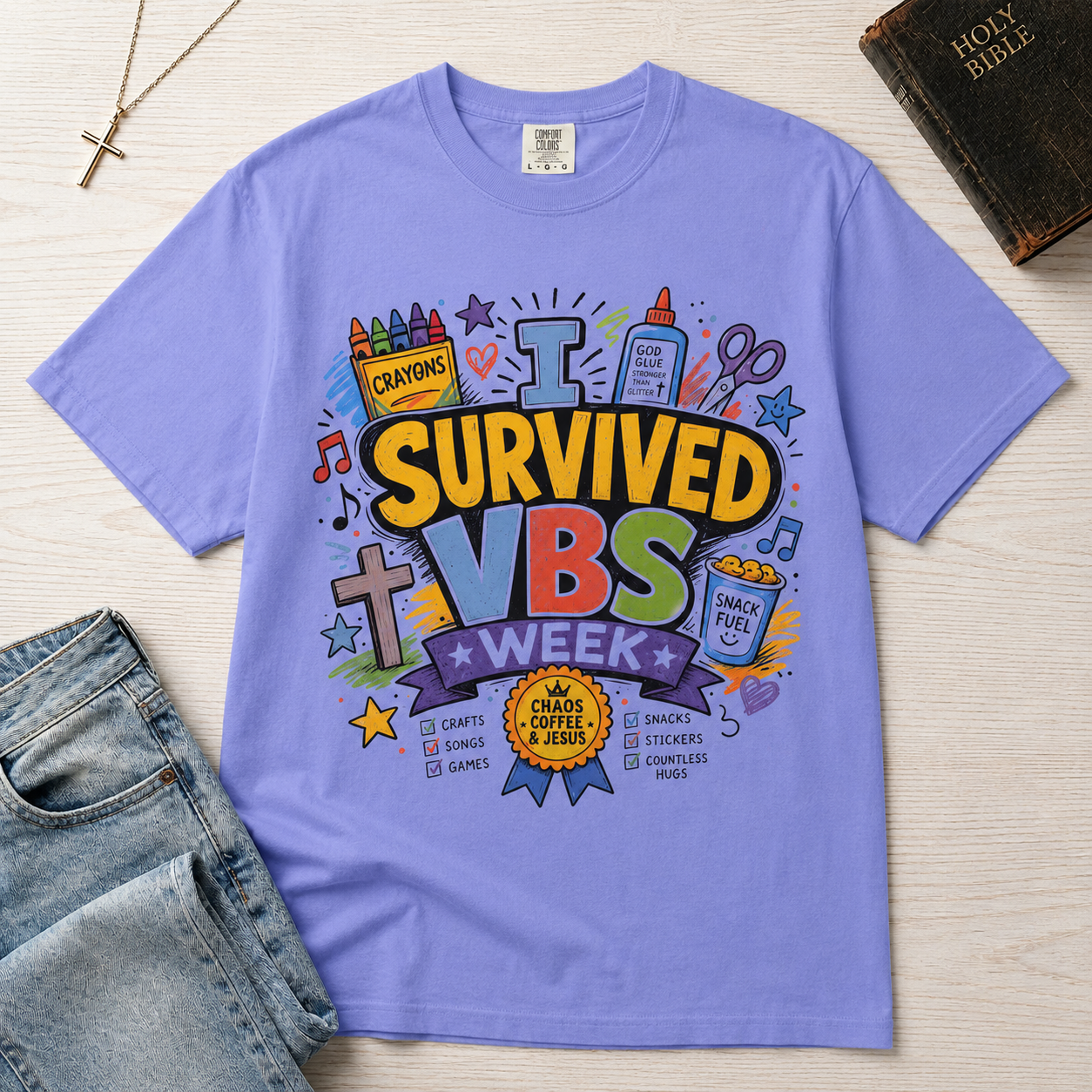 I Survived VBS Week Christian t-shirt in periwinkle; playful graphic with crayons, cross, juice box, stars and an award ribbon, VBS souvenir tee.